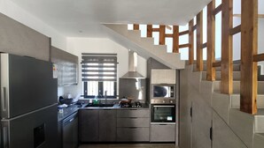 A modern kitchen with a built-in oven, microwave, and stainless steel refrigerator. - Lux Villa in Island of Mauritius, Grand Baie hidden Gem with poolside Bliss (Grand Baie)
