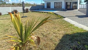 A modern two-story house with a swimming pool, a well-maintained lawn, and a palm tree. - Lux Villa in Island of Mauritius, Grand Baie hidden Gem with poolside Bliss (Grand Baie)