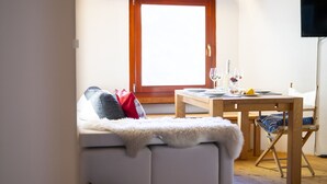 Una camera accogliente con un letto, un tavolo da pranzo apparecchiato per due persone e una finestra con vista.