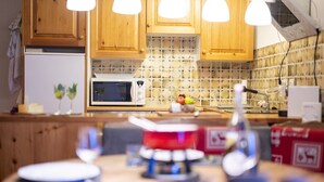 Una cocina con armarios de madera, un microondas y un salpicadero de azulejos.
