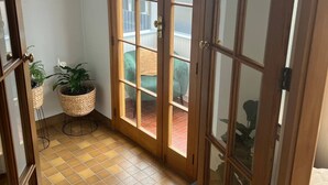 A room with a large sliding glass door leading to a balcony, a small indoor plant, and a tiled floor. - Heart of Windsor (Invercargill)