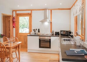 Een compacte keuken met een centraal eiland, een inbouwoven, een magnetron en een spoelbak.