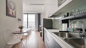Eine moderne Küche mit Edelstahlgeräten, ein Essbereich mit Tisch und Stühlen sowie ein Balkon mit Aussicht.