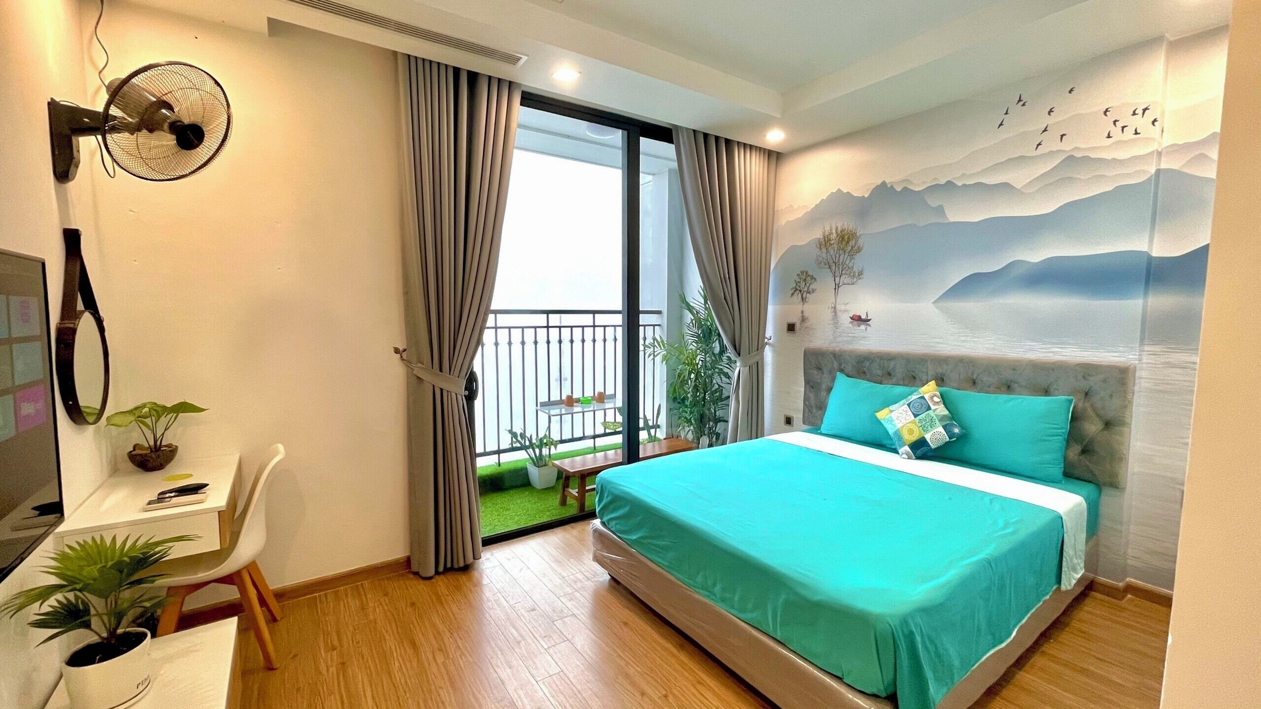 Une chambre moderne avec un lit, un bureau et un balcon.
