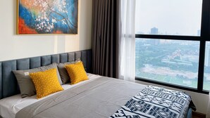Ein modernes Hotelzimmer mit einem großen Bett, Blick auf die Stadt, einem Bild an der Wand und einem Fenster mit Vorhängen.