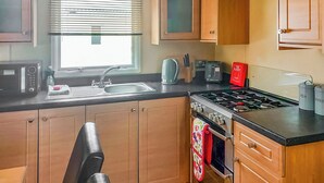 A compact kitchen with a sink, stove, and various appliances.