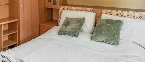 A hotel room with a bed, a wardrobe, and a small bedside table.