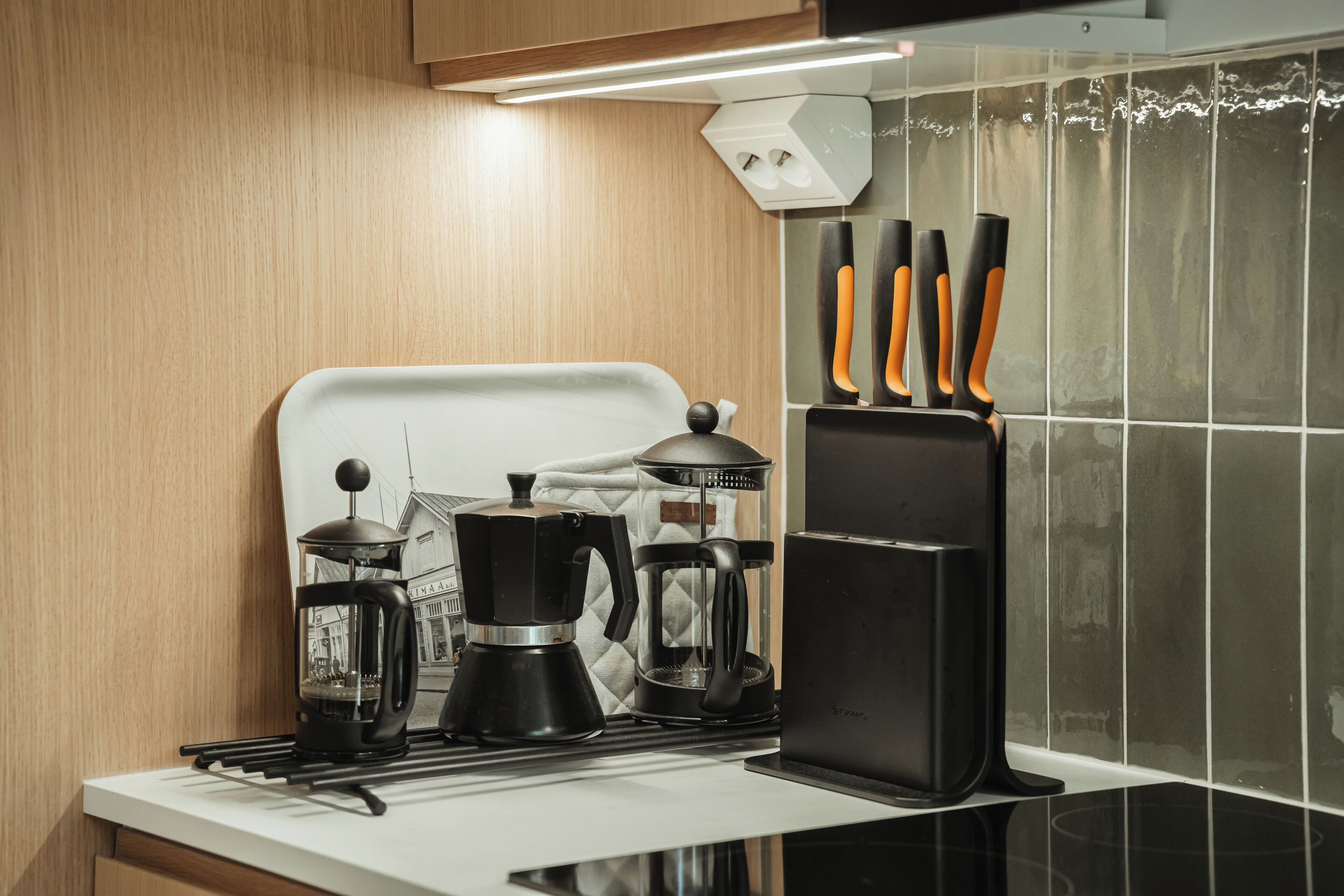 Cozinha com fogão, cafeteira e porta-facas.