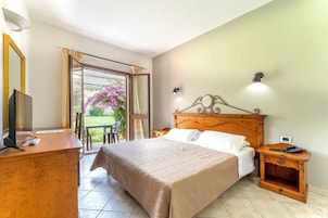 Un dormitorio con cama, mesita de noche, escritorio y silla.