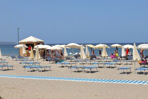 Playa privada, sillas reclinables de playa, sombrillas