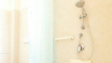 A bathroom with a shower, toilet, and a towel rack.
