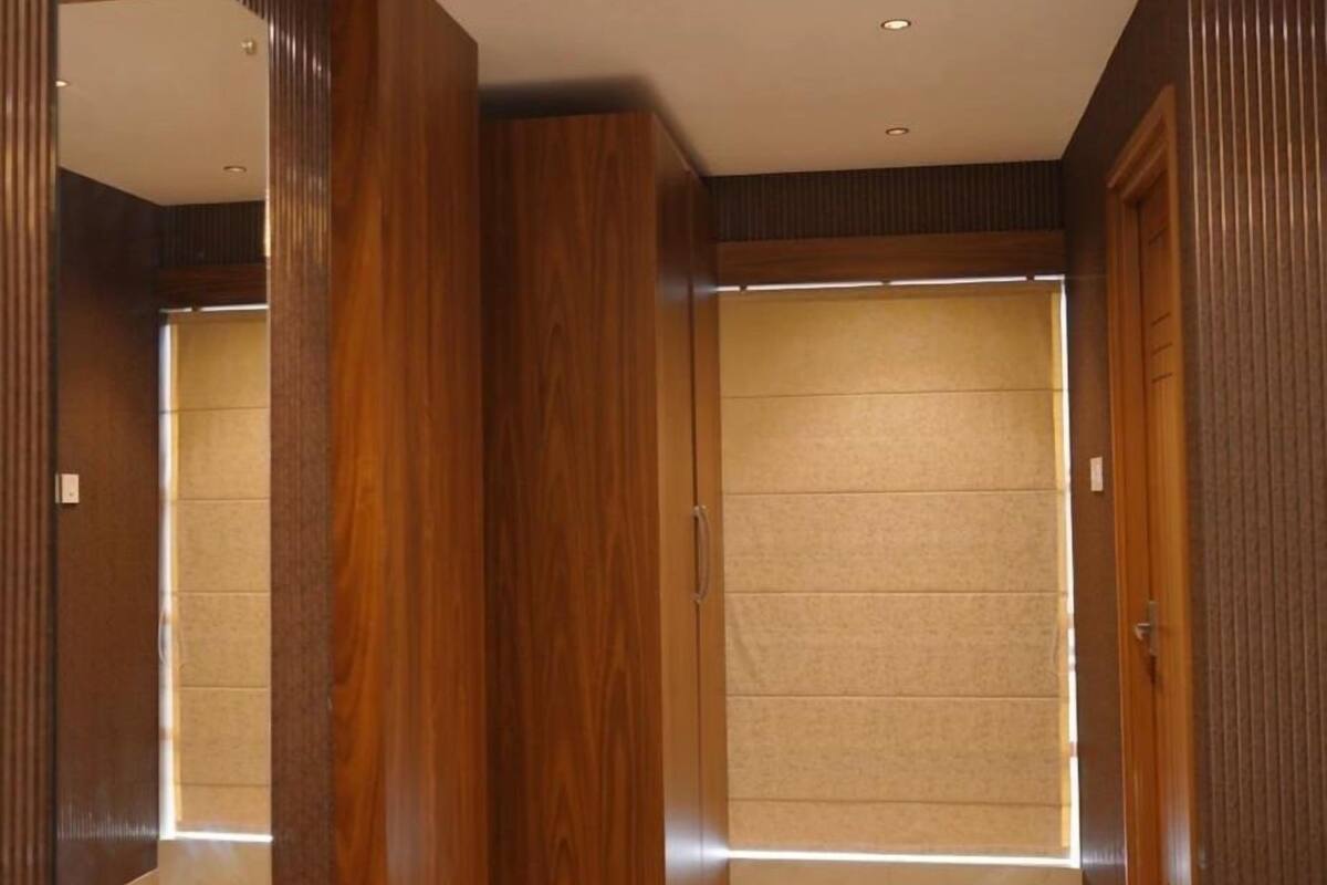 Ein modernes Interieur mit einem Holzesstisch und -stühlen, einem großen Spiegel und einer Schiebetür zu einem anderen Raum.