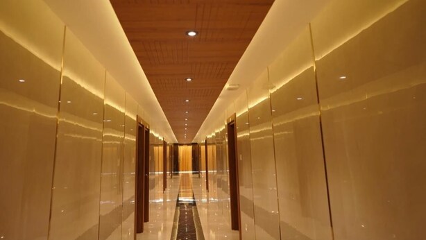 A long, narrow hallway with reflective walls and a wooden ceiling. - Mountain View Tourist Home (Thamarassery)
