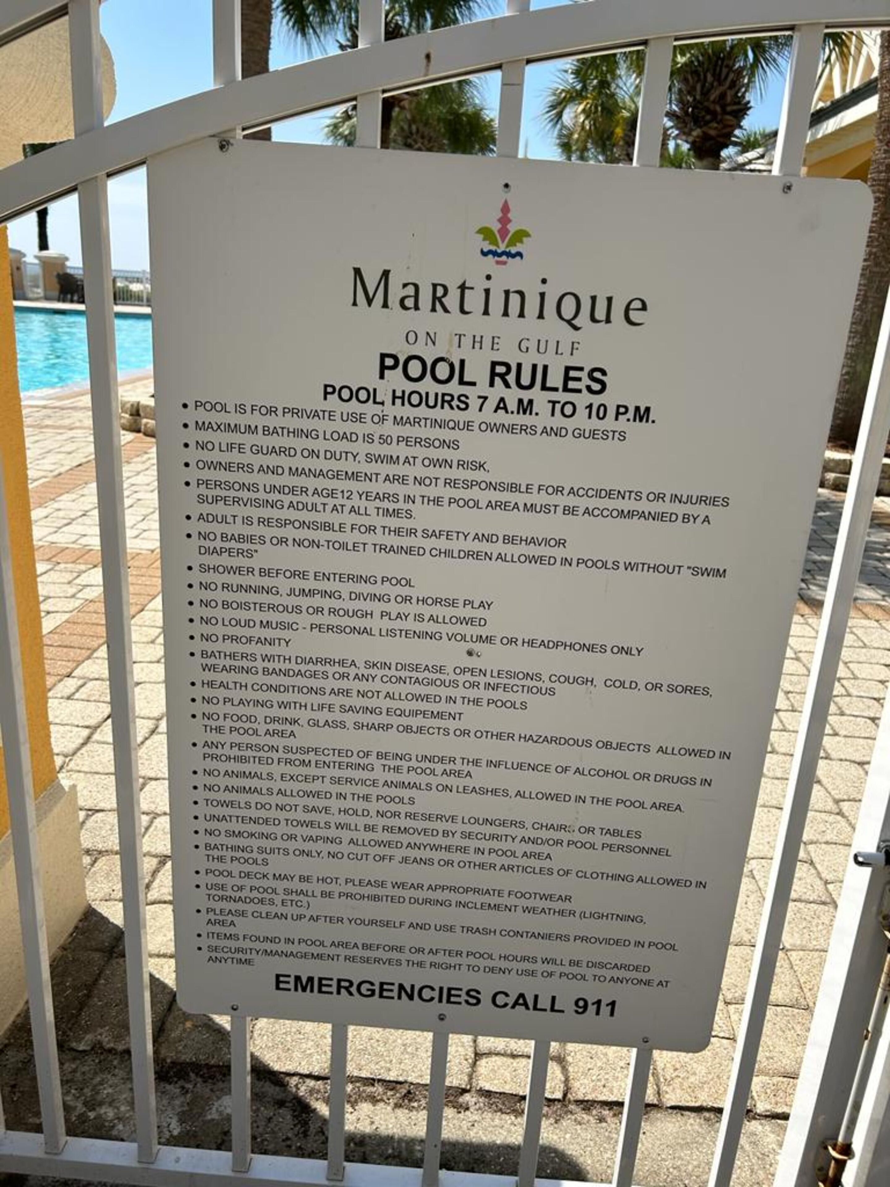 A sign listing pool rules for Martinique on the Gulf, including hours, maximum capacity, and safety guidelines.