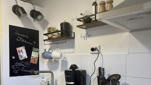 A modern kitchen with a blackboard, coffee machine, and various kitchen utensils.
