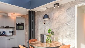 Eine moderne Küche mit weißen Schränken, einem schwarzen Backofen und einer Arbeitsplatte mit Küchenutensilien.