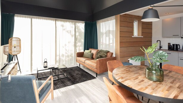 Ein modernes Wohnzimmer mit Sofa, Couchtisch und Essbereich.