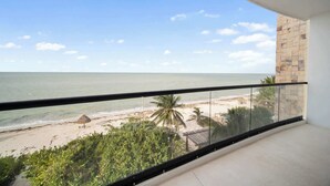 Un balcon avec vue sur une plage et l’océan.
