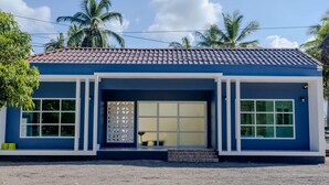 A two-story building with a tiled roof, large windows, and a covered entrance. - Rungmod 99 Villa (Khanom)