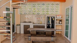 A modern kitchen with a central island, a built-in oven, and a refrigerator. - Rungmod 99 Villa (Khanom)