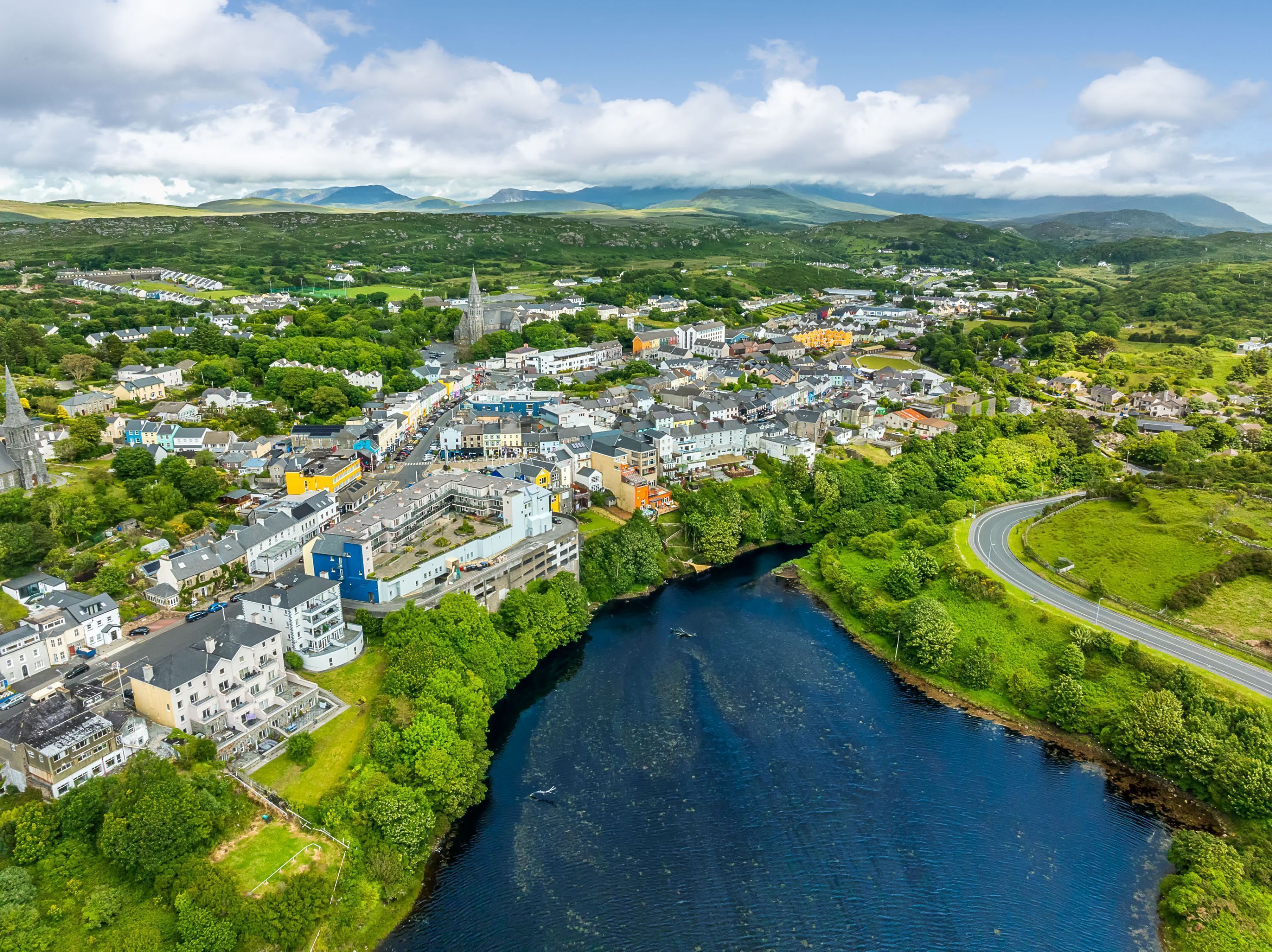 An aerial view of a town with a river, buildings, and a church.