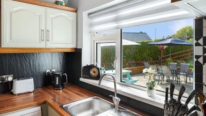Een keuken met een groot raam, een broodrooster, een koffiezetapparaat en een radio.