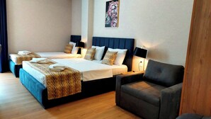 A hotel room with two beds, a sofa, and a painting on the wall. - Falcon Boutique Hotel (Tbilisi)