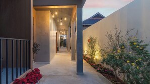 A modern building with a concrete exterior, a covered walkway, and outdoor lighting. - Mê Villa Dalat (Xuan Huong - Da Lat)