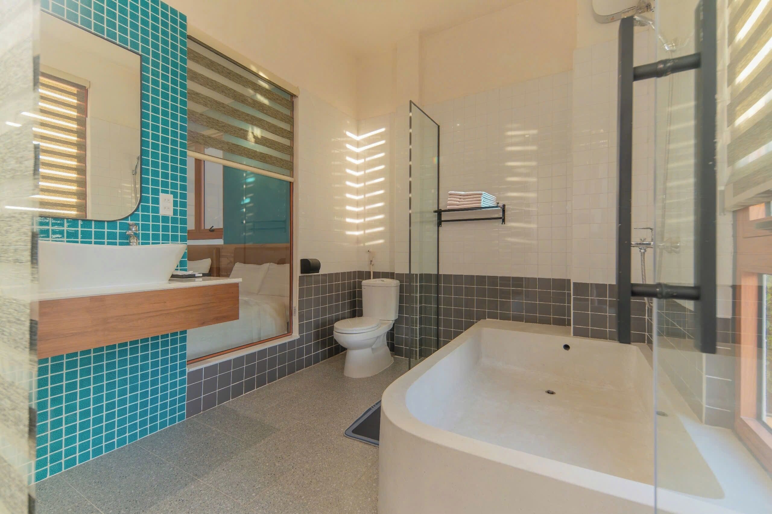 Ein modernes Badezimmer mit einer großen Badewanne, einer Toilette, einem Waschbecken mit Spiegel und einer Duschkabine.