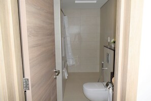 A bathroom with a toilet, a shower, and a towel rack. - Comfy STU - Almultaqa Mirdif (Dubai)