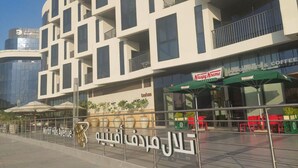 En modern byggnad med en skylt som visar texten ”Mirdf Hills Avenue” och en butik som säljer Krispy Kreme-donuts.