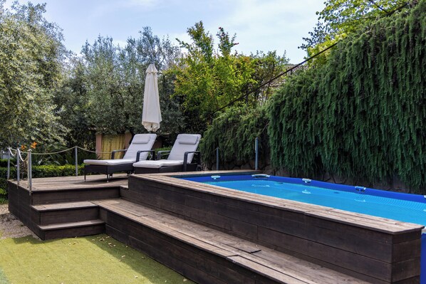 A rectangular swimming pool with a wooden deck and two lounge chairs. - Positano Villa with View - Large Garden and Private Pool - 3 bedrooms 2 bathrooms (Lazio)
