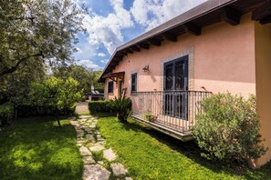 A house with a stone pathway leading to the entrance, surrounded by greenery and a clear sky. - Positano Villa with View - Large Garden and Private Pool - 3 bedrooms 2 bathrooms (Lazio)
