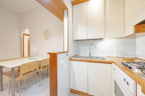 Apartamento Confort | Cocina privada | Frigorífico grande, horno, placa de cocina y máquina de café espresso