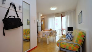 Ein kompakter Wohnbereich mit Sofa, Esstisch und Fernseher.