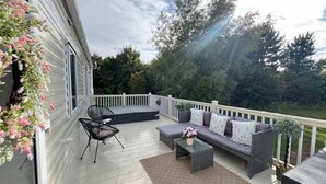 A covered outdoor deck with a sofa, chairs, and a small table. - 3bed-8berth- Hot Tub-mablethorpe-pet Friendly-wifi (Mablethorpe)