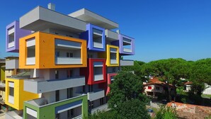 Ein mehrstöckiges Gebäude mit außergewöhnlichem architektonischen Design und farblich unterschiedlichen Bereichen.