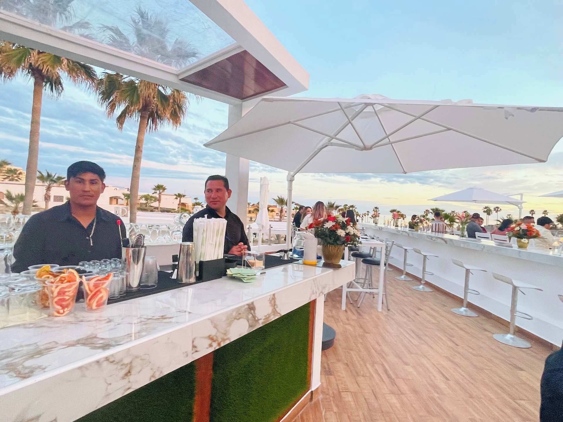 Eine Bar mit Marmorplatte, Barhocker und Meerblick.