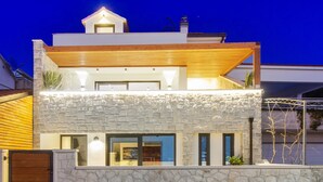 A modern two-story house with a stone facade, a wooden upper floor, and a gated entrance. - Beachfront Villa, Indoor Heated pool with Stunning view (Vinišce)