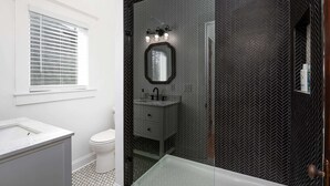 Ein Badezimmer mit weißem Waschbecken, Toilette und einer Duschkabine.