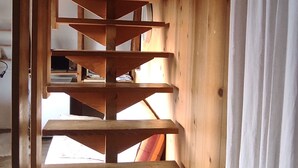 Una escalera espiral de madera con varios niveles, que conduce a un piso superior.