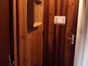 Une porte en bois avec une poignée en métal et une petite découpe rectangulaire.