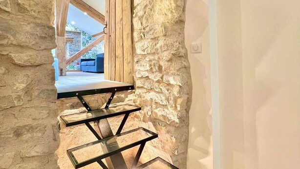 A narrow staircase with a glass table at the top, leading to a balcony with a blue chair. - Charming 4-Bedroom Cottage with Modern Comfort (Haroué)
