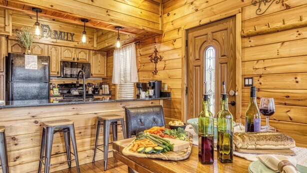 L’intérieur d’un chalet en bois comprend une cuisine, un coin repas et un bar.