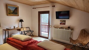 A bedroom with two beds, a desk, a chair, a TV, and a window with a view. - 2 rooms 4 pers 3* in Valloire, south, WiFi, parking, balcony (Valloire)