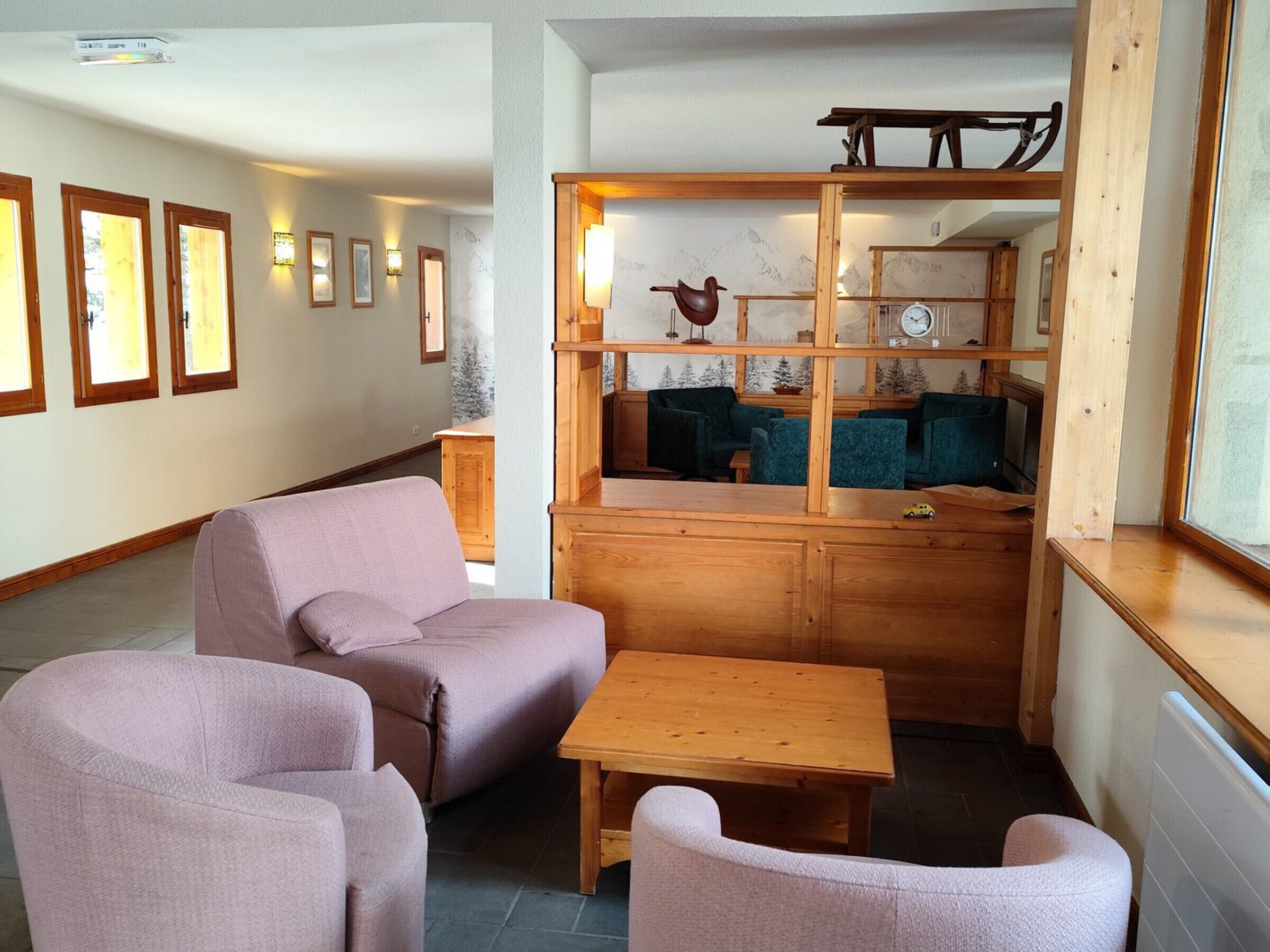 Un salon chaleureux avec un banc en bois, deux fauteuils confortables et une petite table.