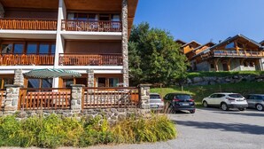 Un hôtel à plusieurs étages, doté de balcons en bois et de murs en pierre.