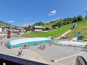 A ski resort with a large covered area, ski lifts, and a mountainous backdrop.