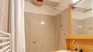 Un baño con una bañera, un lavabo con espejo y una ducha.