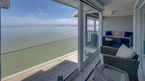 Ein Balkon mit Korbmöbeln und Blick auf den Ozean.